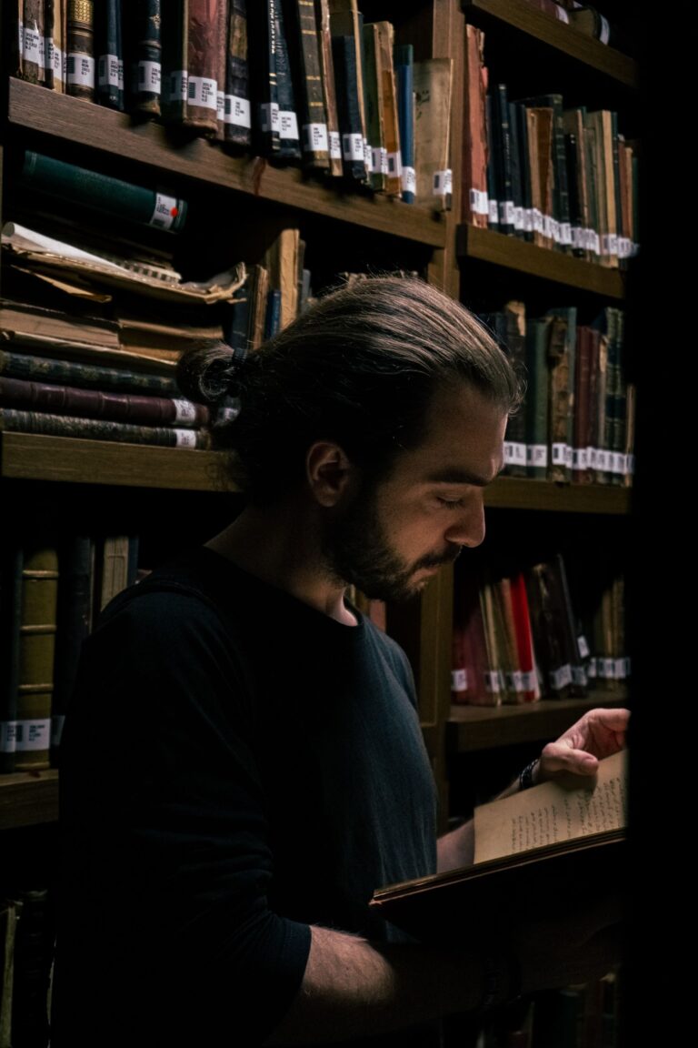 Homem estudando livro antigo manuscrito em biblioteca de obras esotéricas