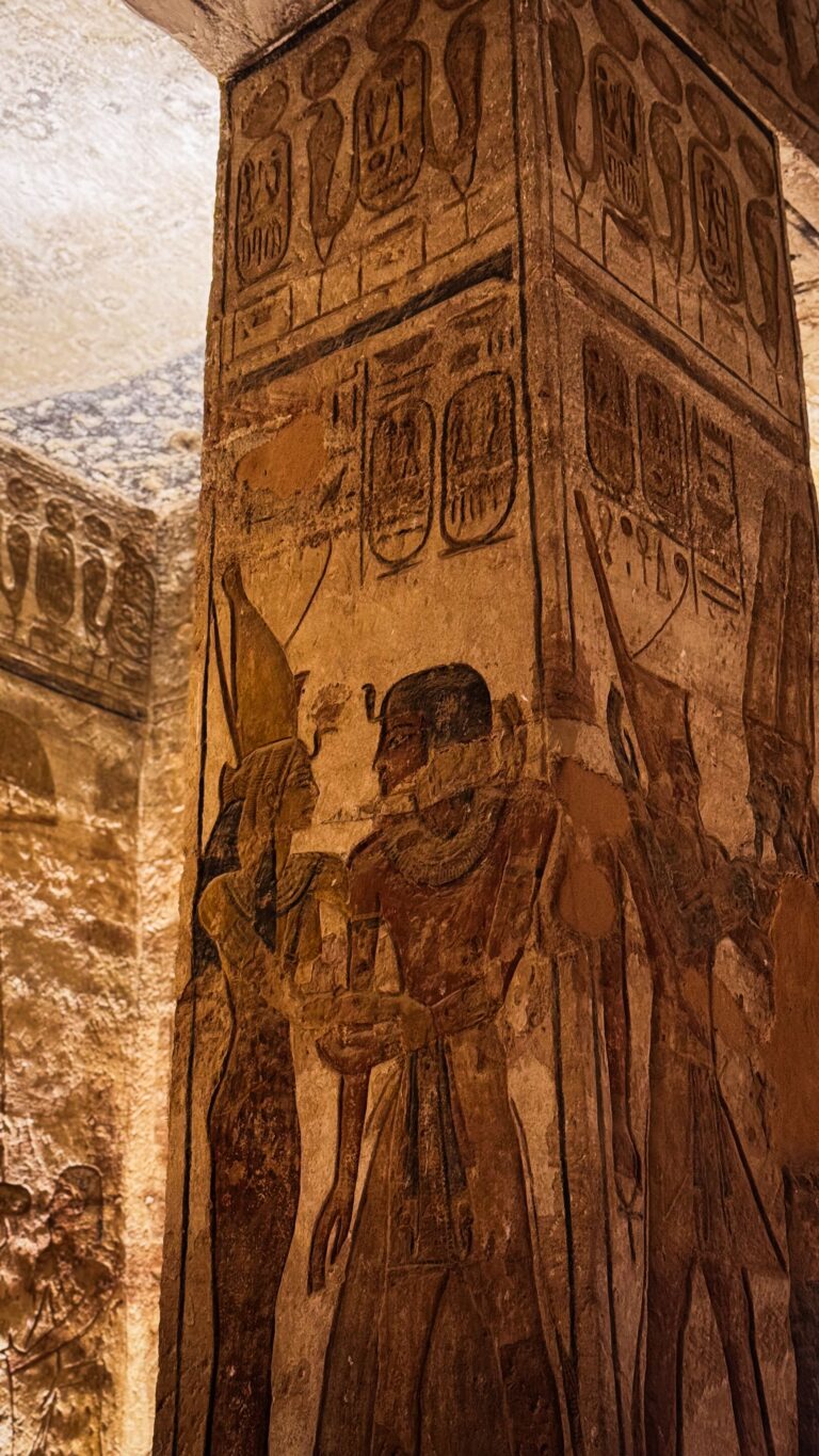 Relevo egípcio antigo com hieróglifos e figuras divinas esculpidas em coluna de templo