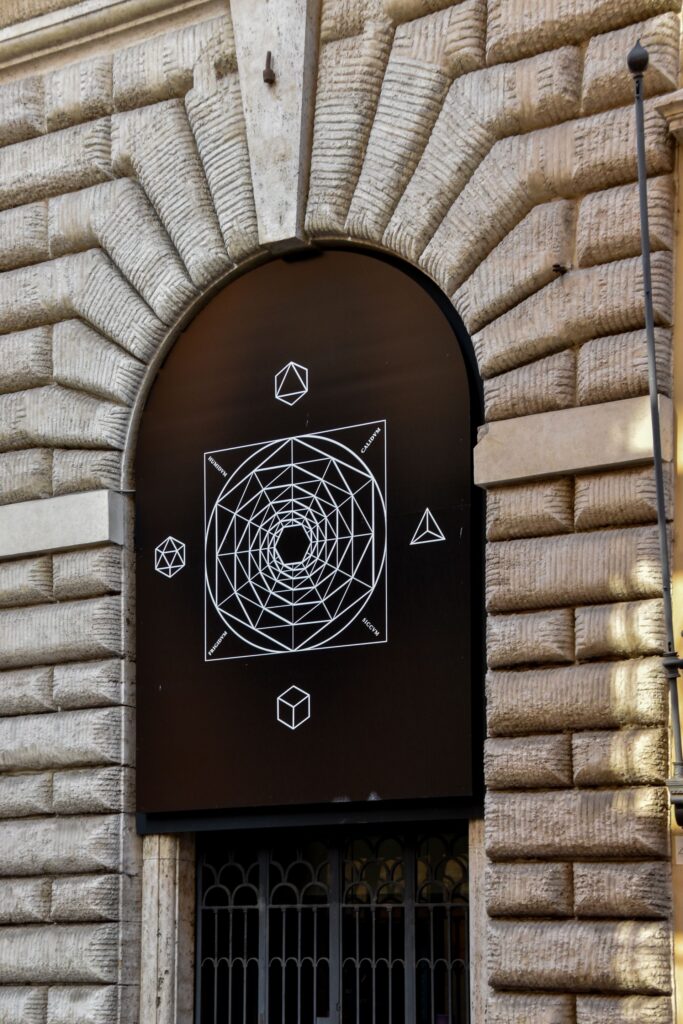 Portal de pedra antigo com símbolos alquímicos gravados — a Porta Alquímica, representando os elementos e o selo hermético da Grande Obra