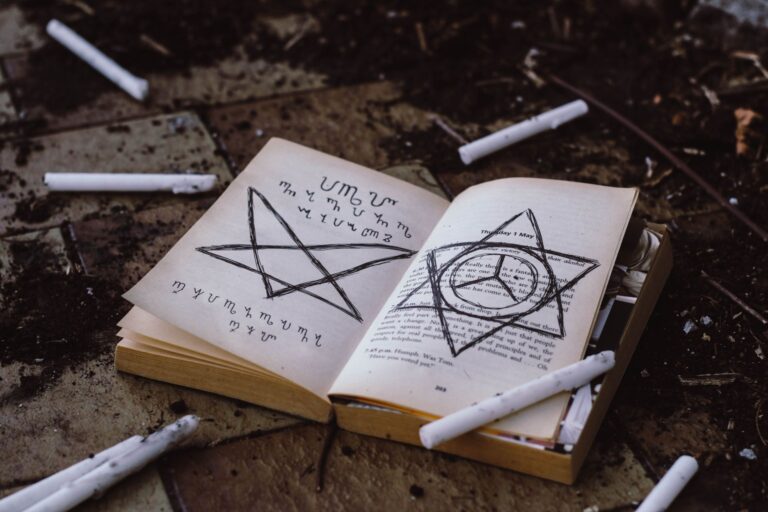 Livro aberto com símbolos de proteção e pentagramas desenhados à mão, cercado por gizes brancos, em cena de ritual de proteção