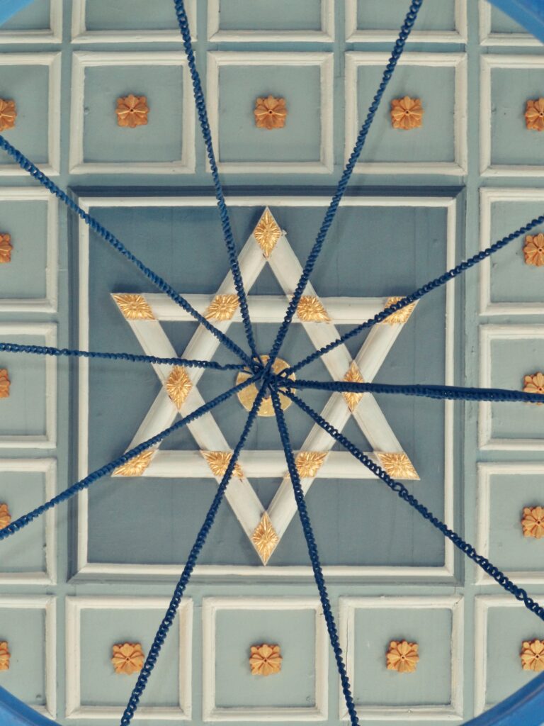 Estrela de seis pontas dourada ornamentada em teto simbólico, remetendo à Árvore da Vida cabalística